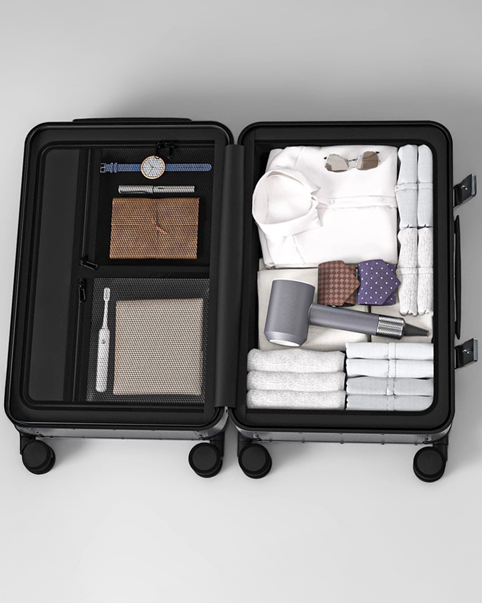 Open black suitcase with neatly packed items on a light gray background